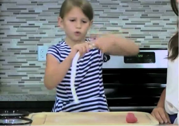 Kid demonstrating how to twist the polymer clay