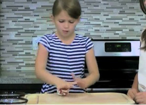 Kid demonstrating how to flatten the clay