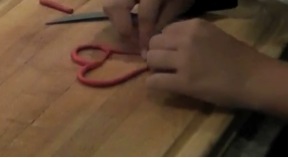 Demonstrating how to add loops to the heart pendant