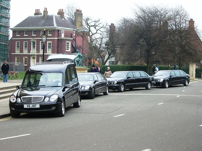 Funeral limousines parked in front of a church